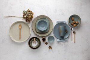 A selection of blue and beige earthy tones handmade pottery styled in a flat lay