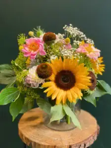 Bouquet of Flowers on a rustic wooden surface with dark green background photographed for florist product gallery
