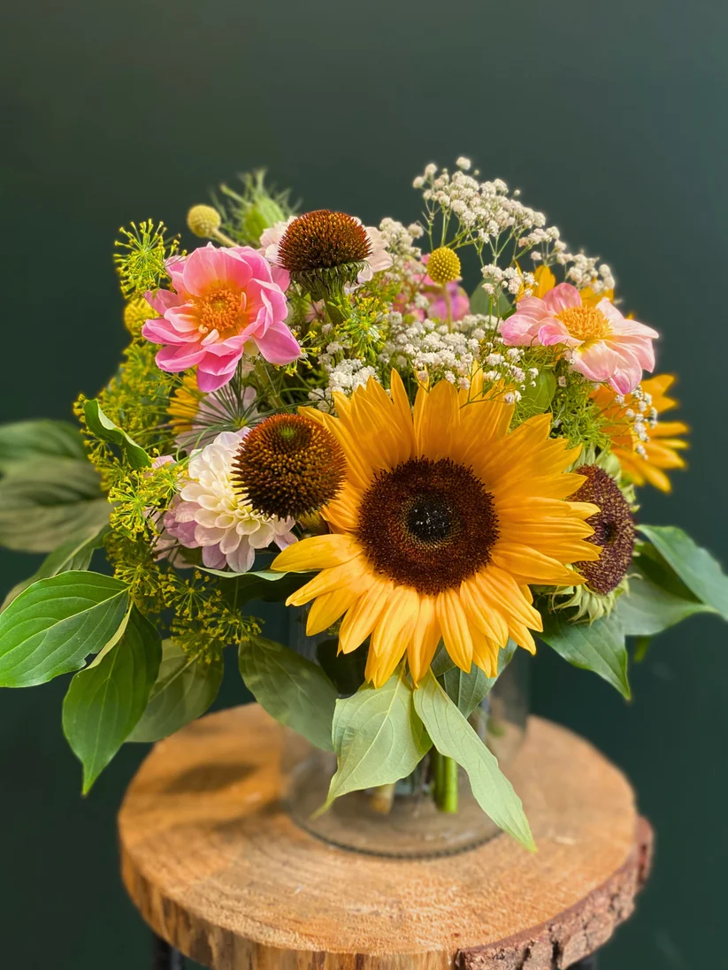 Bouquet of Flowers on a rustic wooden surface with dark green background photographed for florist product gallery